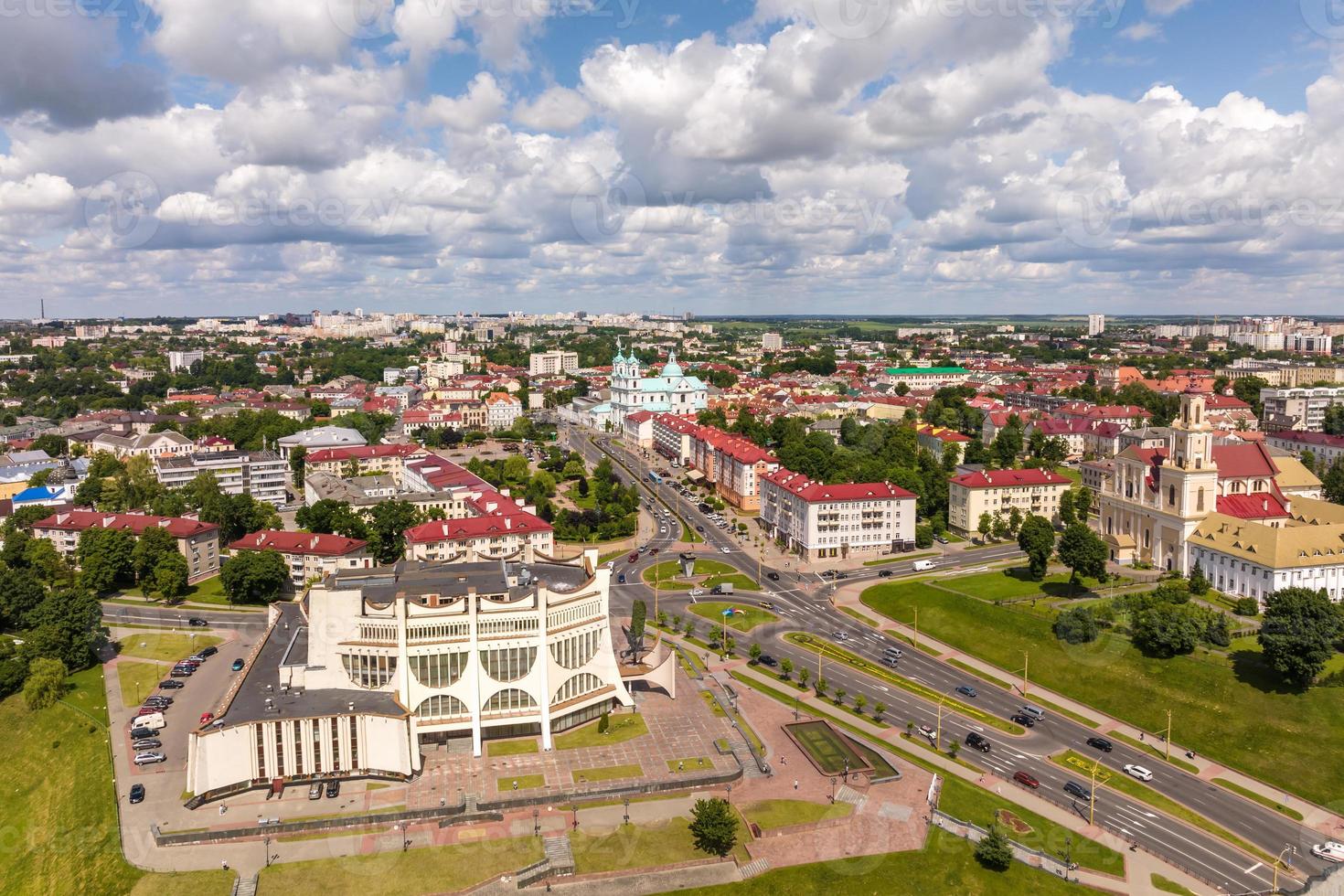 aerial panoramic view from great height on red roofs of old big city with skyscrapers and white fluffy clouds photo