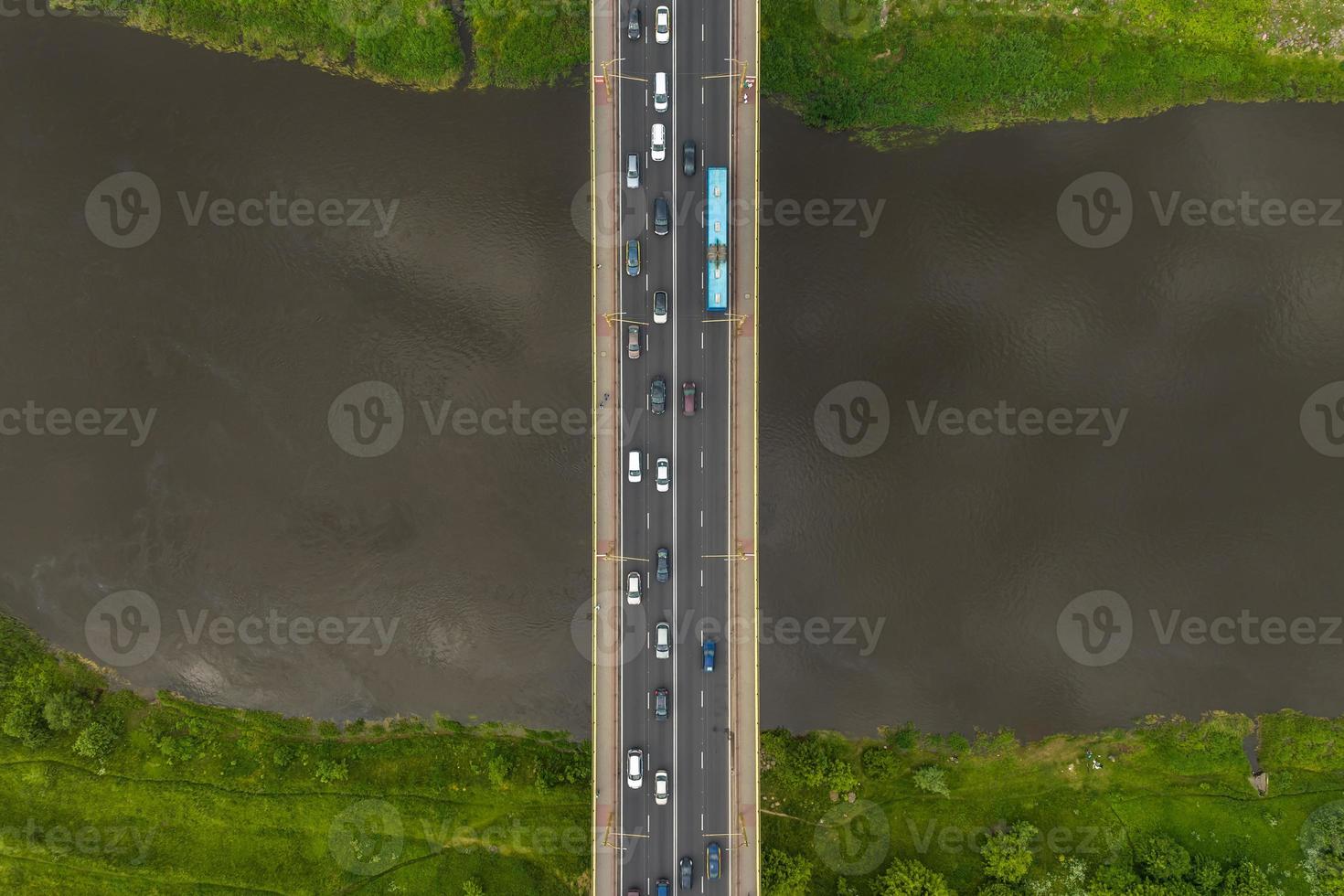 aerial view on heavy traffic on a bridge with a wide multi-lane road across a wide river photo