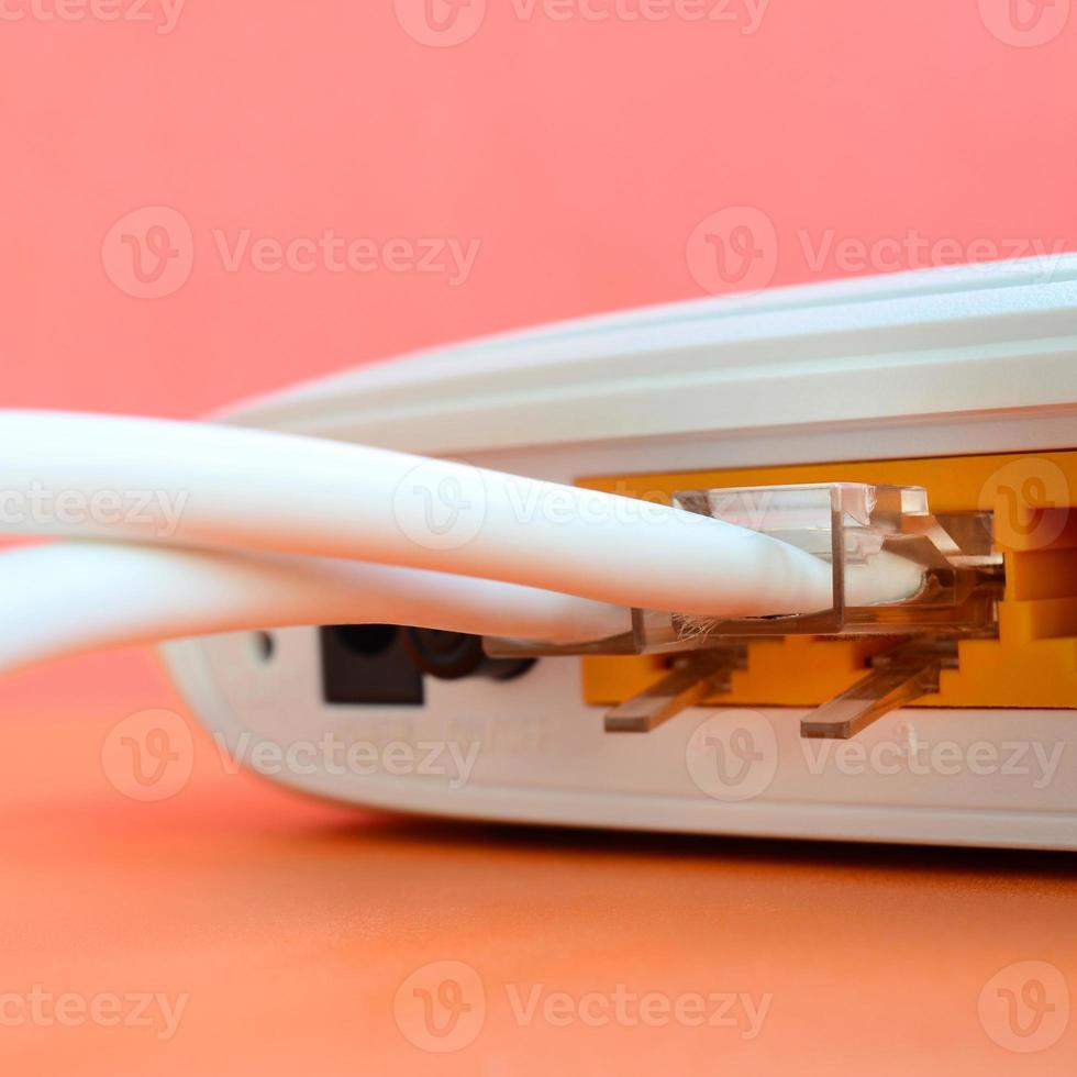 The Internet cable plugs are connected to the Internet router, which lies on a bright orange background. Items required for Internet connection photo