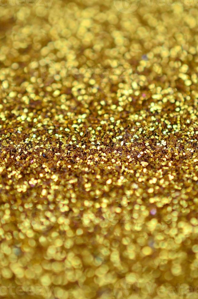 A huge amount of yellow decorative sequins. Background texture with shiny, small elements that reflect light in a random order. Glitter texture photo