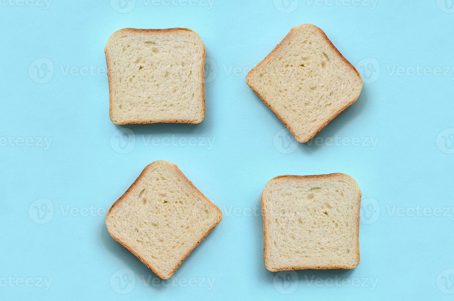 A few pieces of bread lies on texture background of fashion pastel blue color paper in minimal concept photo