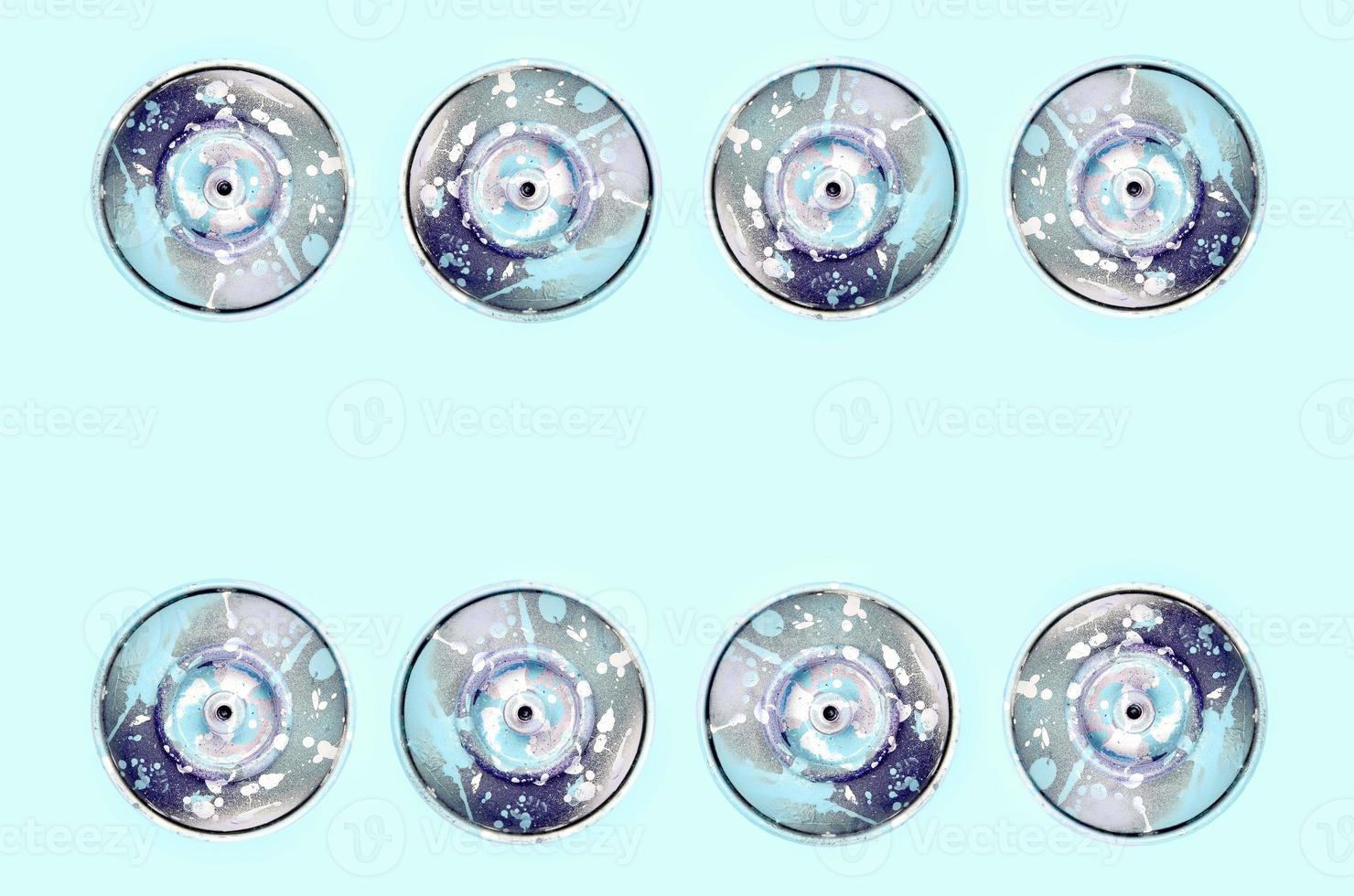 Many used spray cans for graffiti drawing lies on a pastel colored backgroung. Street art painting concept. Minimal flat lay pattern. Top view photo