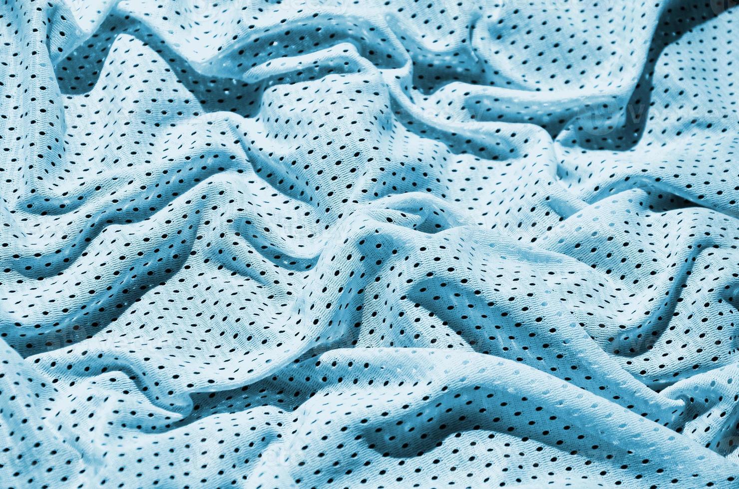 Blue sport clothing fabric texture background. Top view of light blue cloth textile surface. Bright basketball shirt. Text Space photo