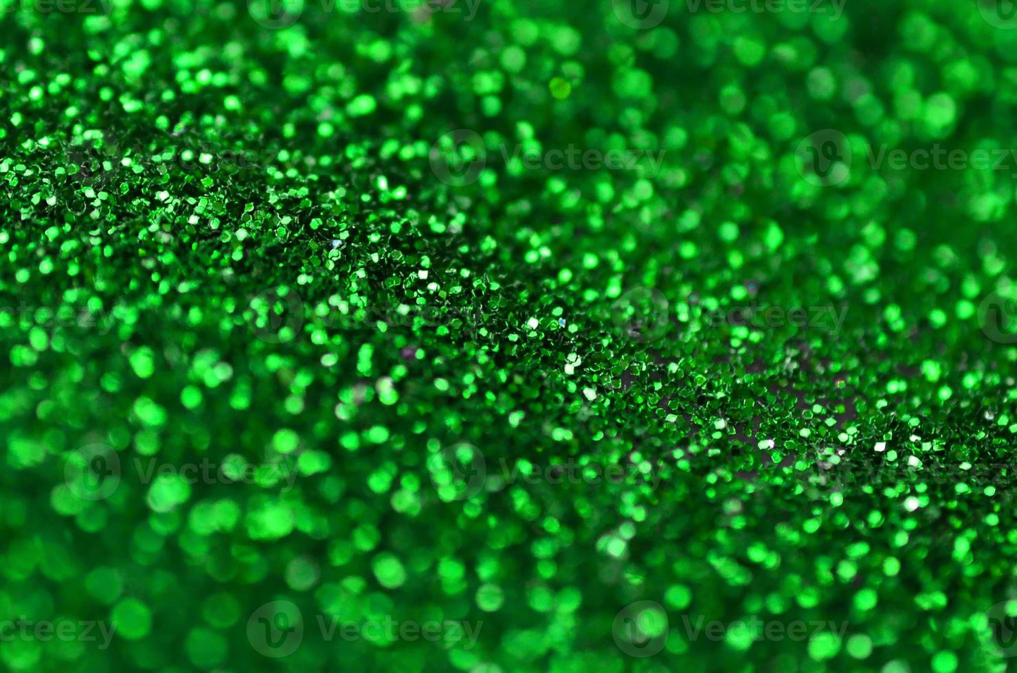 una gran cantidad de lentejuelas decorativas verdes. imagen de fondo con luces bokeh brillantes de elementos pequeños foto