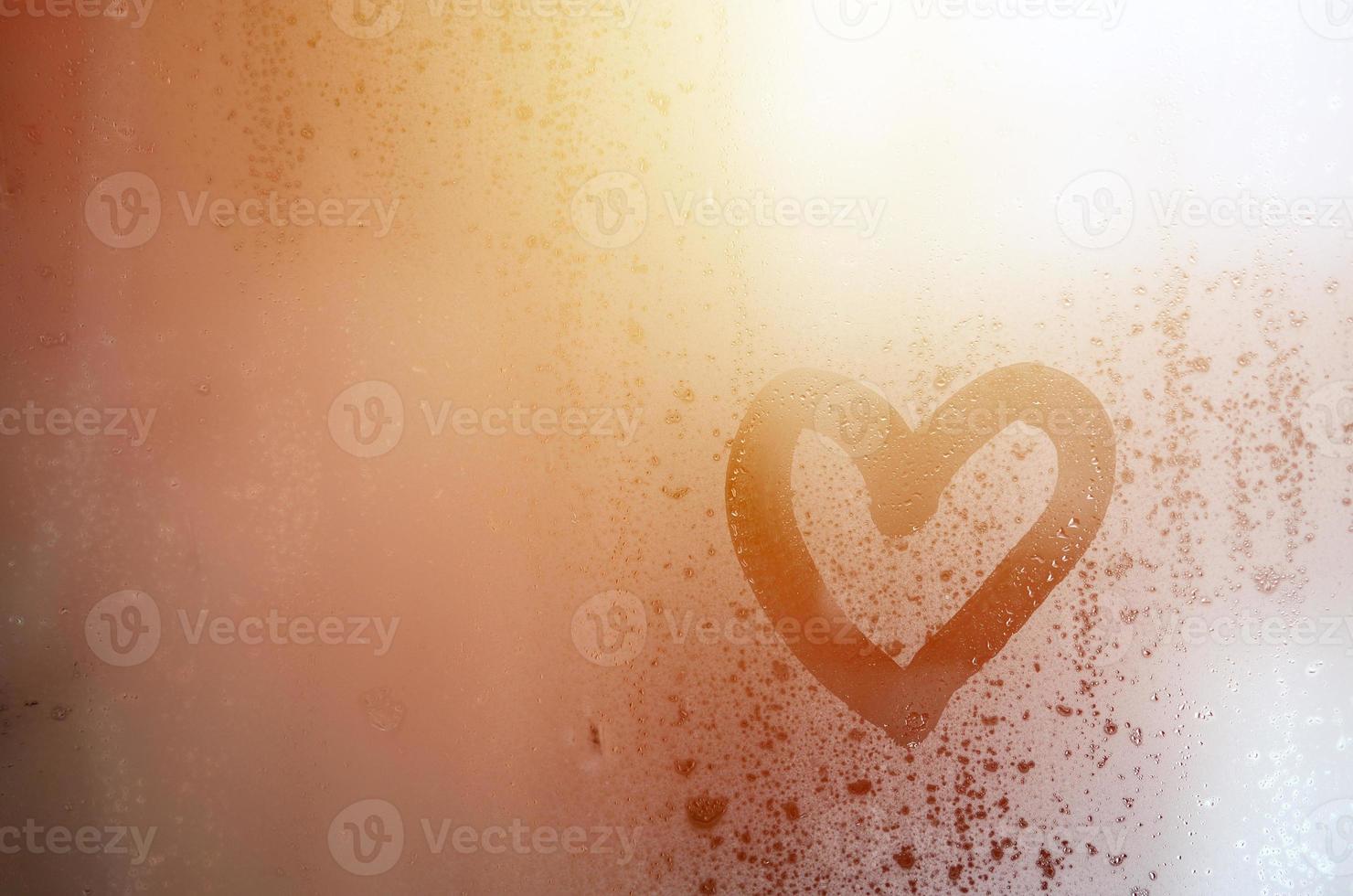 The heart is painted on the misted glass in the winter photo