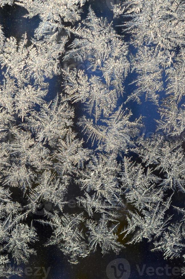 Snowflakes frost rime macro on window glass pane photo