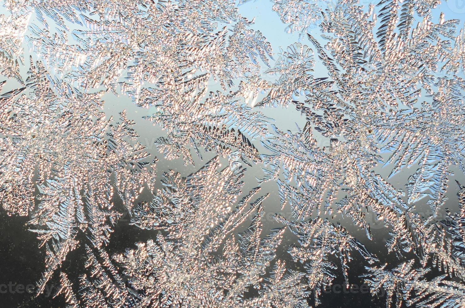 Snowflakes frost rime macro on window glass pane photo