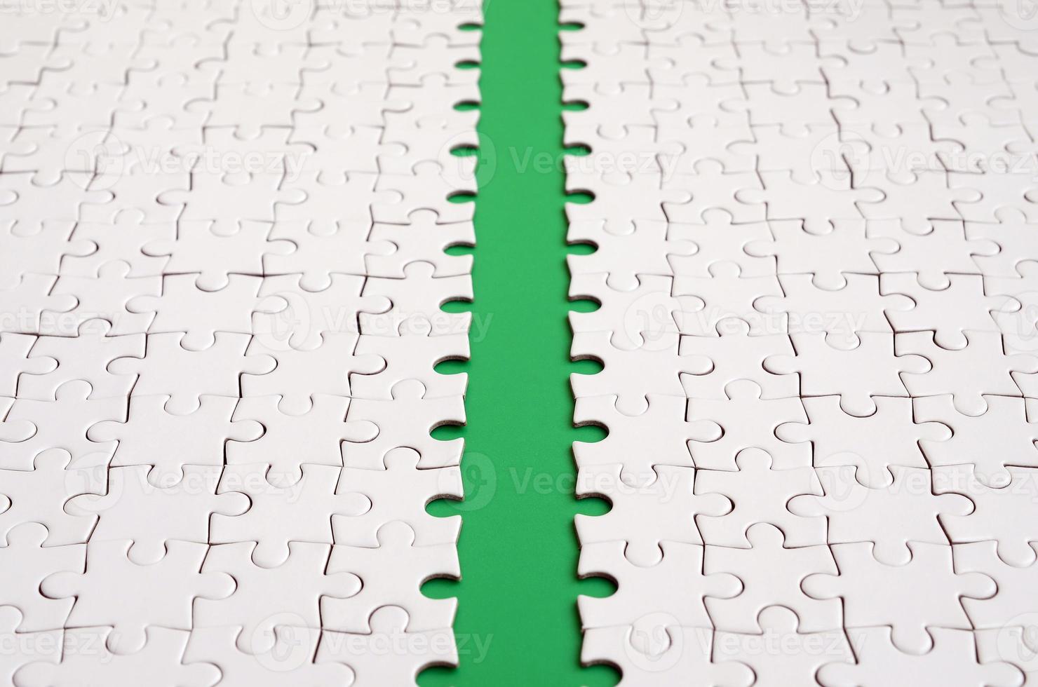 The green path is laid on the platform of a white folded jigsaw puzzle. Texture image with copy space for text photo