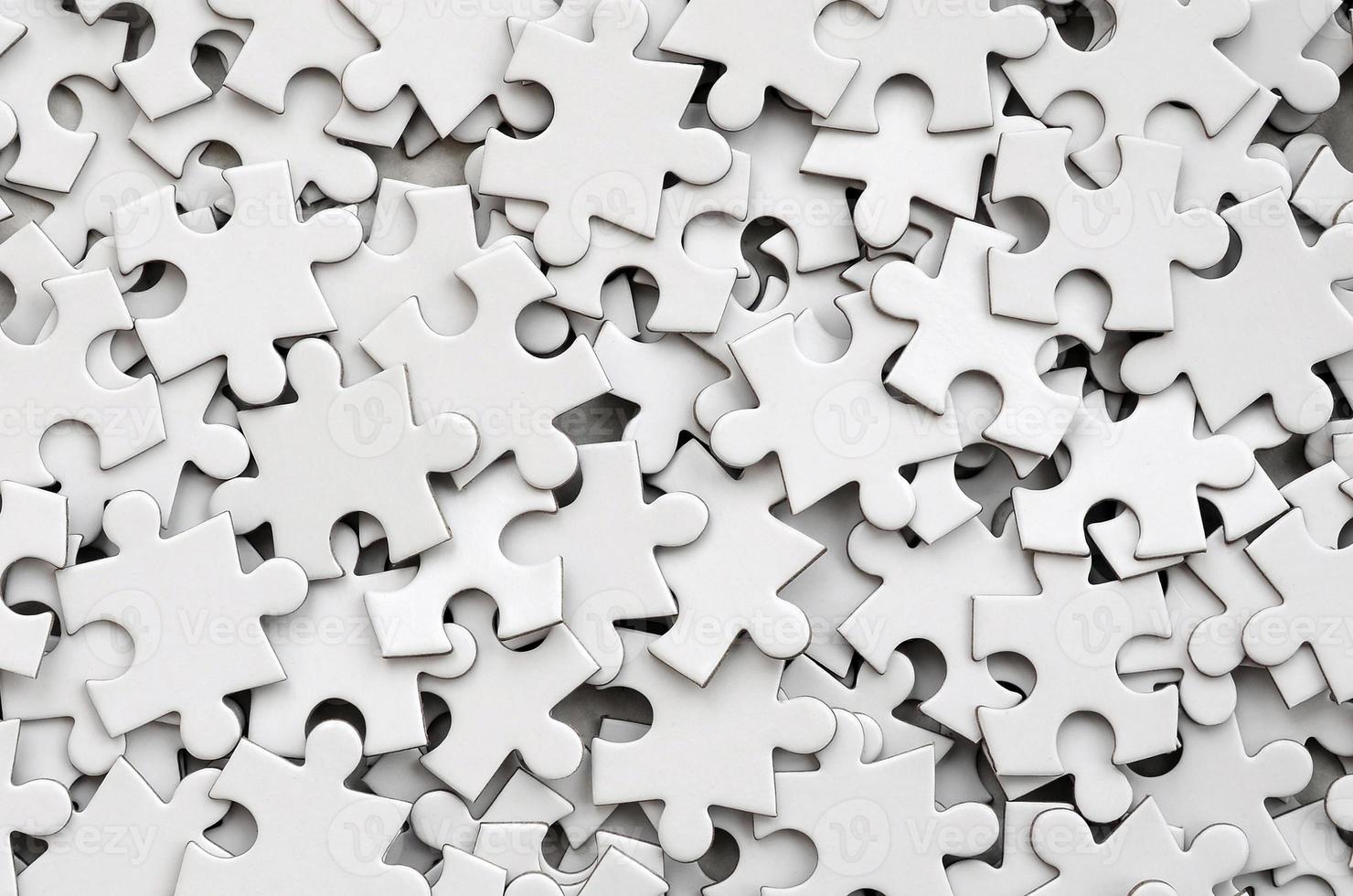 Close-up of a pile of uncompleted elements of a white puzzle. A huge number of rectangular pieces from one large white mosaic photo