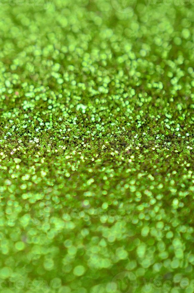 Lime green decorative sequins. Background image with shiny bokeh lights from small elements photo