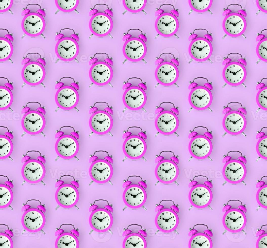 Wasting time concept. Many purple alarm clock photo