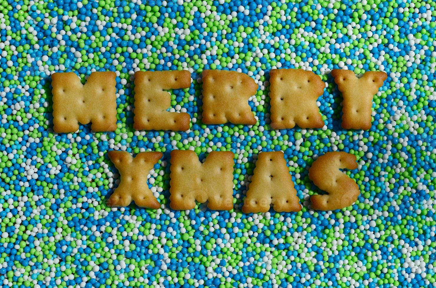 Merry Xmas. The word from the edible letters lies on the glazed powder photo