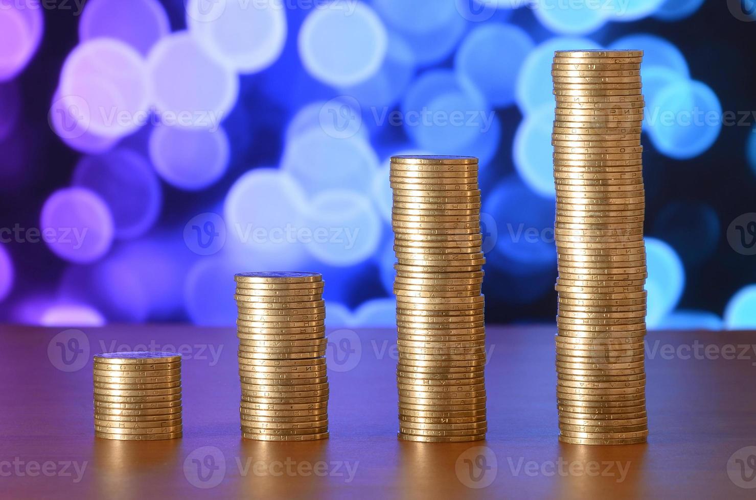 Golden coin stacks arranged as a graph. Increasing columns of coins photo