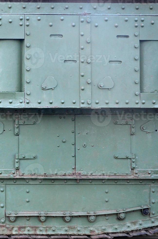 Texture of tank side wall, made of metal and reinforced with a multitude of bolts and rivets photo