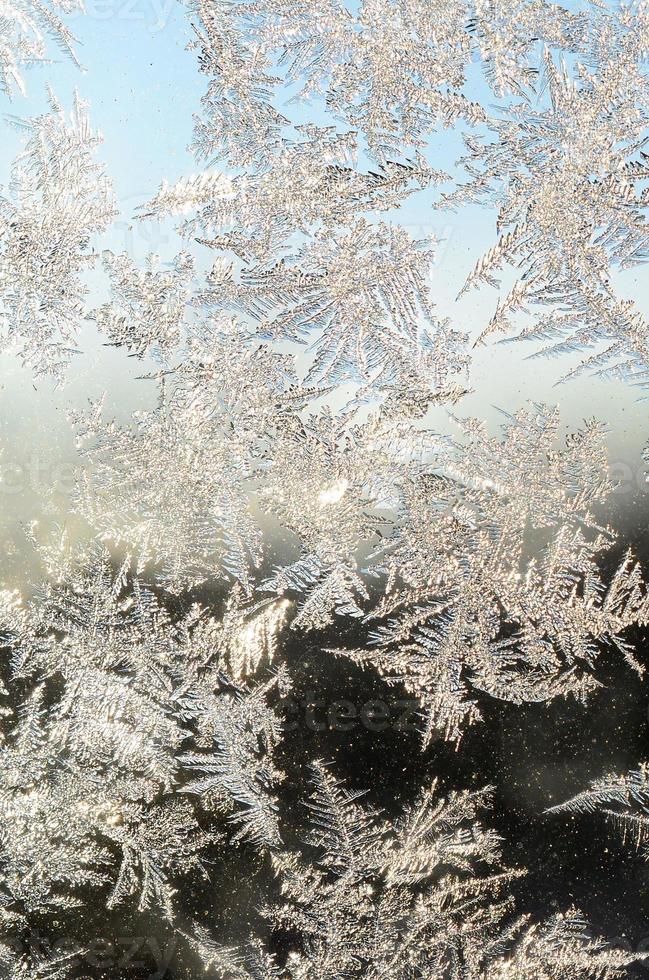 Snowflakes frost rime macro on window glass pane photo