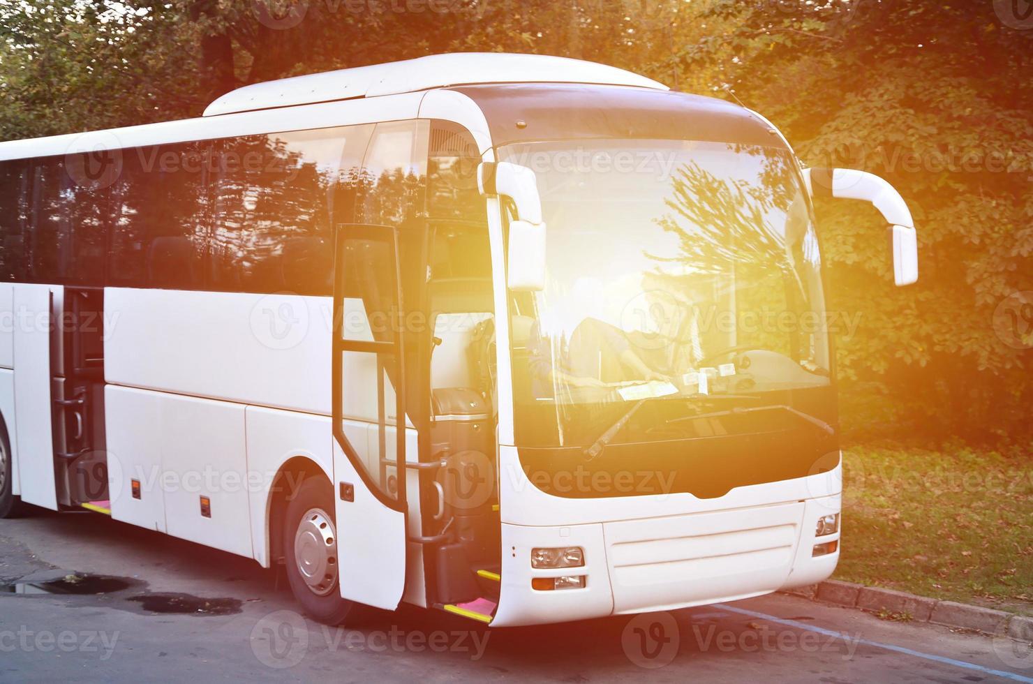 White tourist bus for excursions. The bus is parked in a parking lot near the park photo