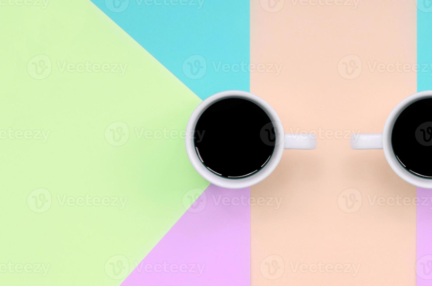 Small white coffee cup on texture background of fashion pastel pink, blue, coral and lime colors paper photo
