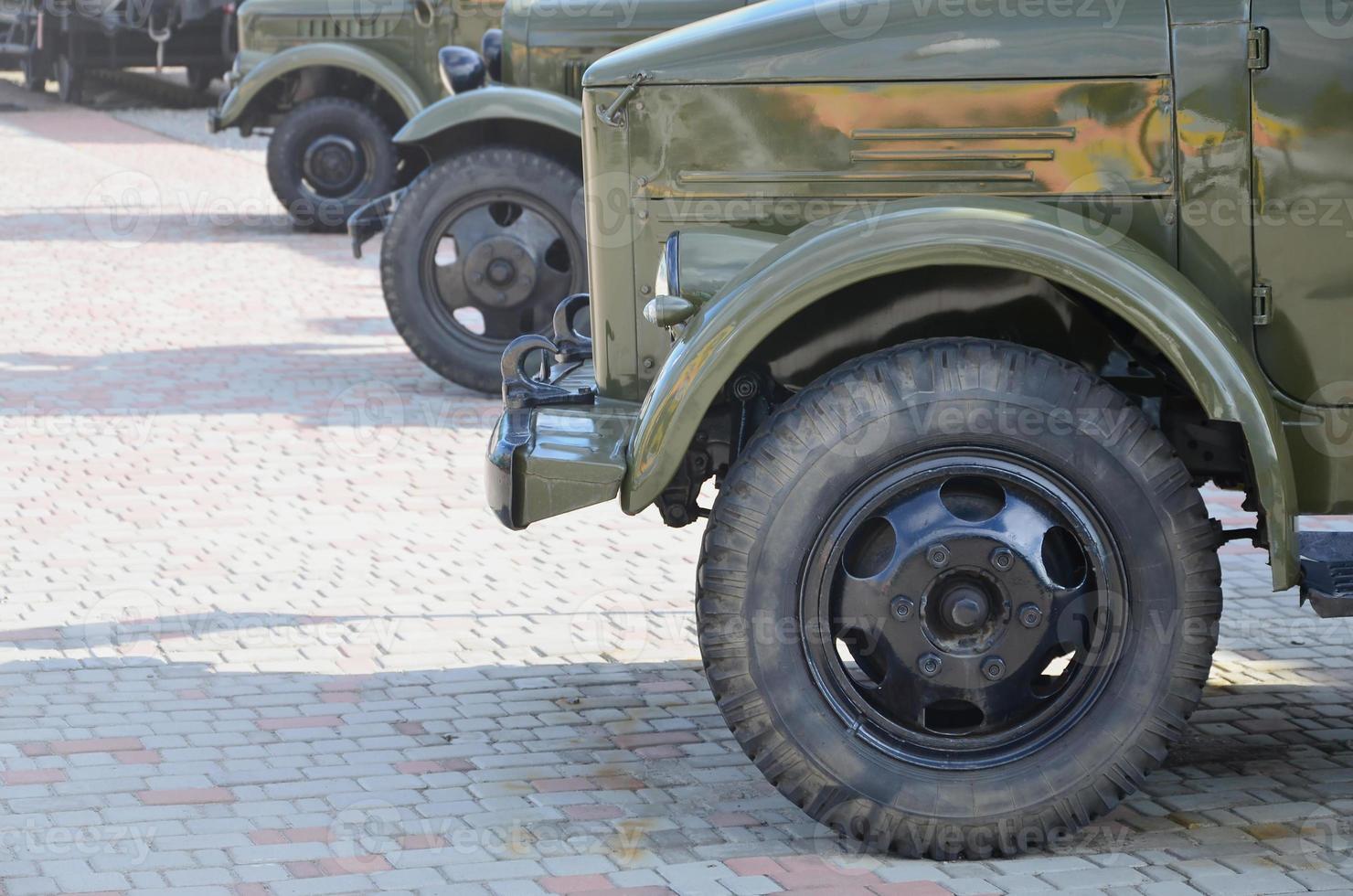 Photo of the cabins of three military off-road vehicles from the times of the Soviet Union. Side view of military cars from the front wheel