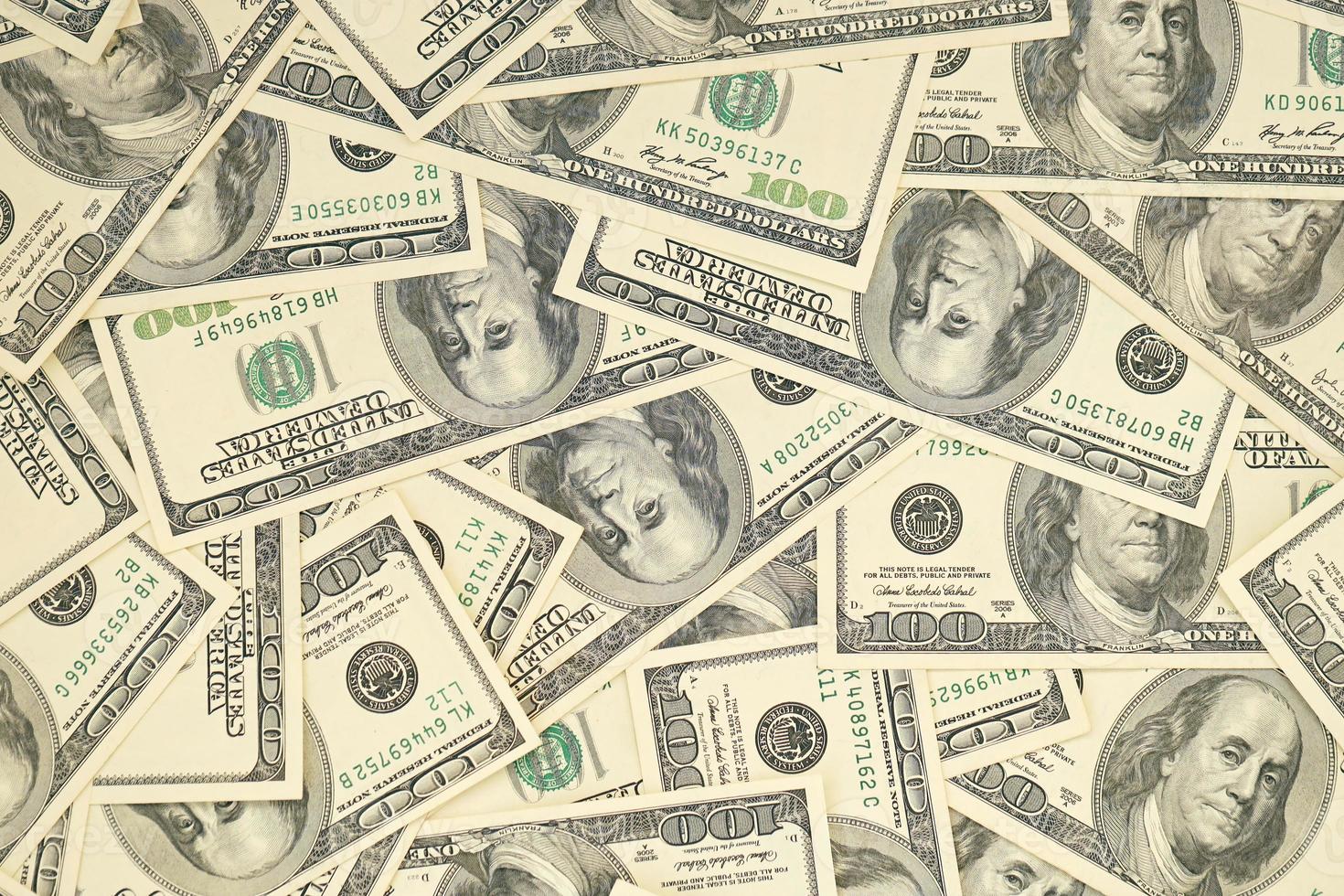 A pile of one hundred US banknotes with president portraits. Cash of hundred dollar bills, dollar background full frame image photo