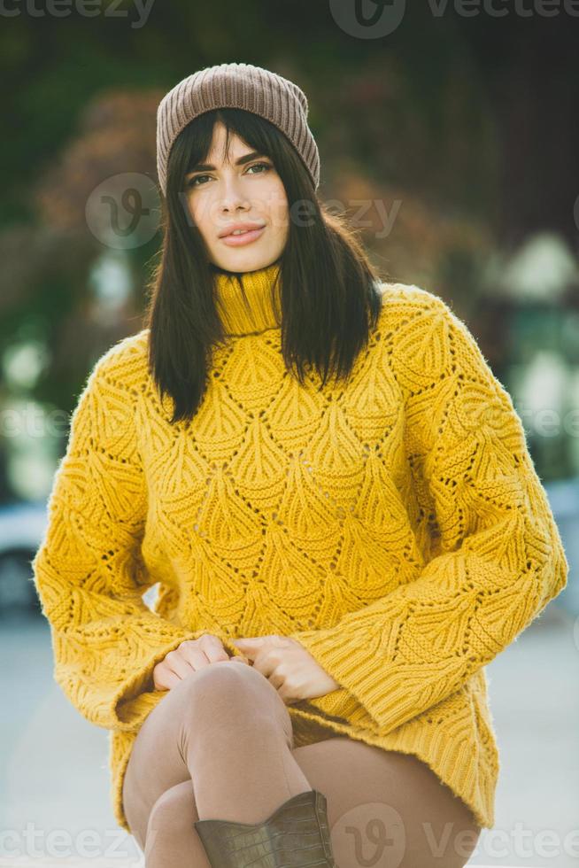 Beautiful European brunette dressed in a yellow woolen sweater and hat  outside. The beautiful girl who wears thick stylish autumn clothes in cool  weather. 12824197 Stock Photo at Vecteezy