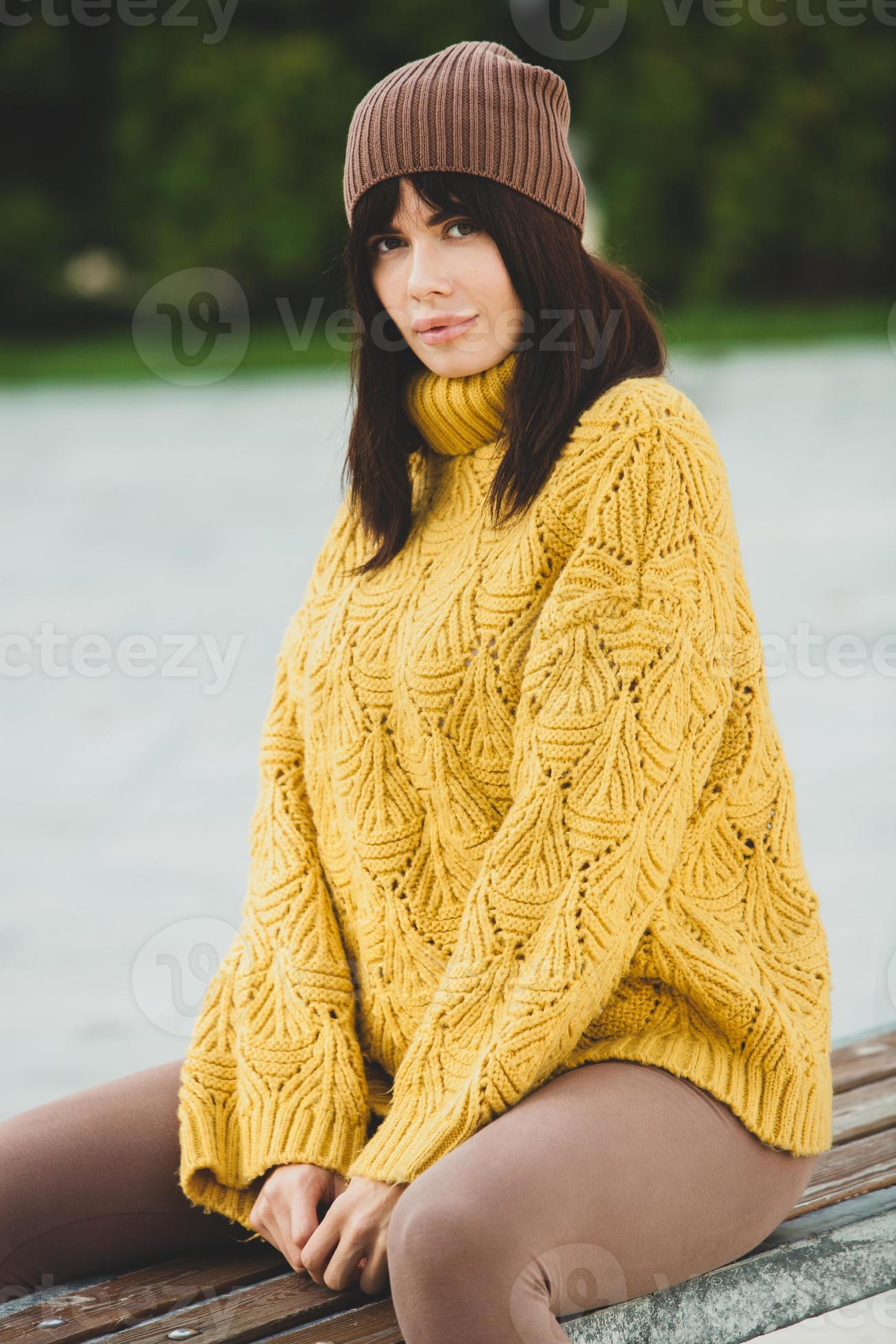 Beautiful European brunette dressed in a yellow woolen sweater and hat  outside. The beautiful girl who wears thick stylish autumn clothes in cool  weather. 12824197 Stock Photo at Vecteezy