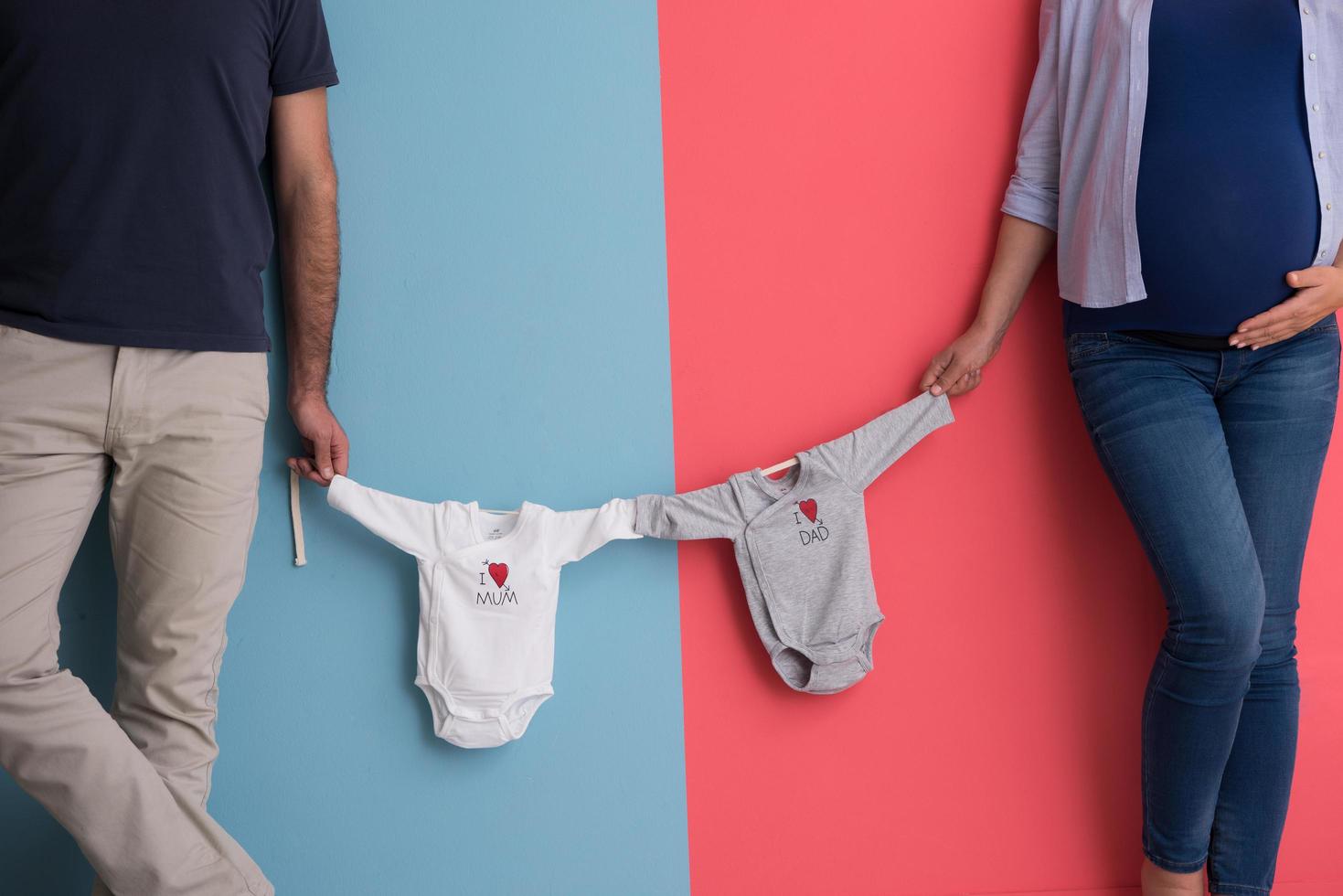 young couple holding baby bodysuits photo