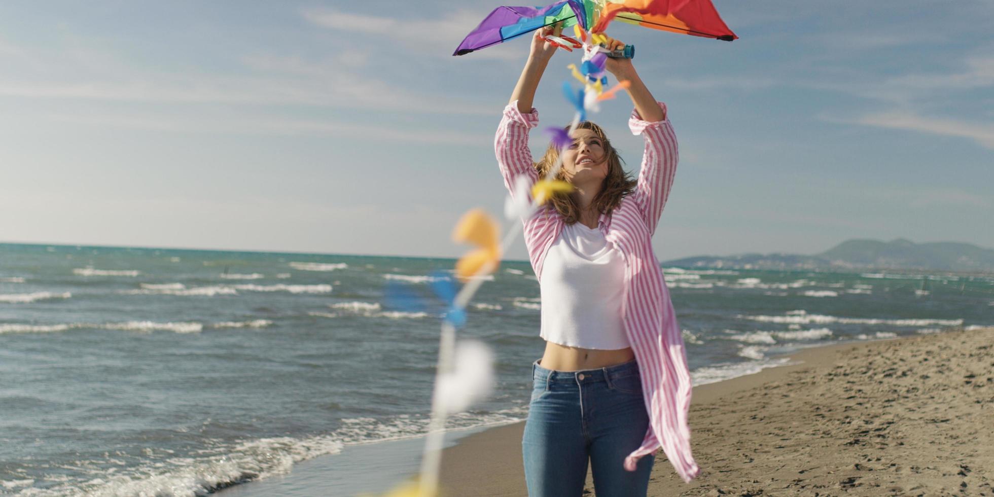 Happy couple having fun with kite on beach photo