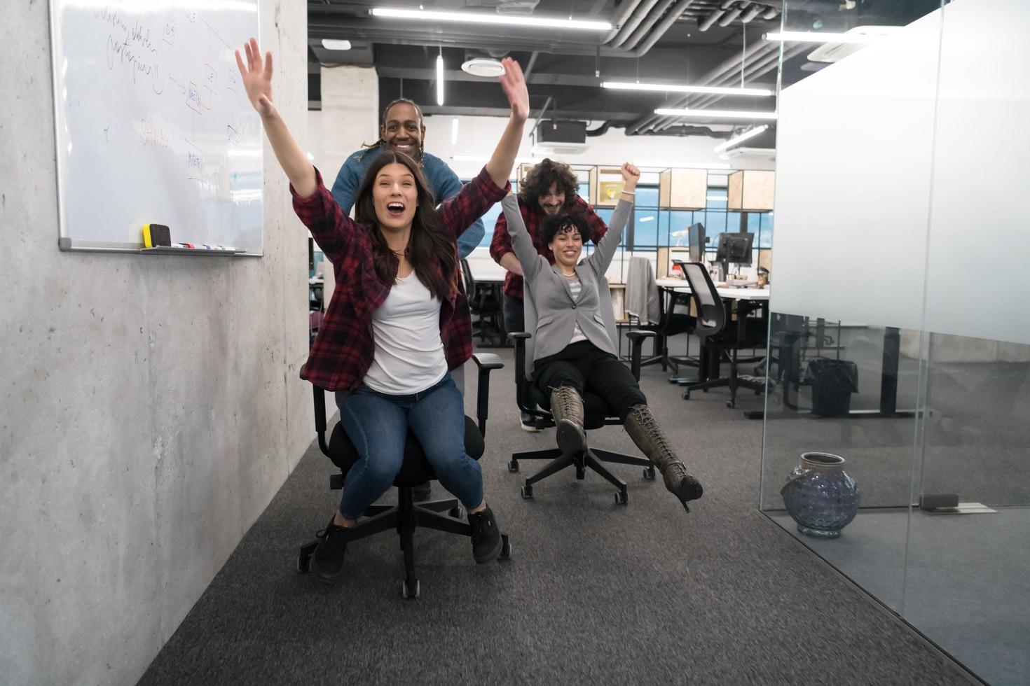 equipo de negocios multiétnico corriendo en sillas de oficina foto