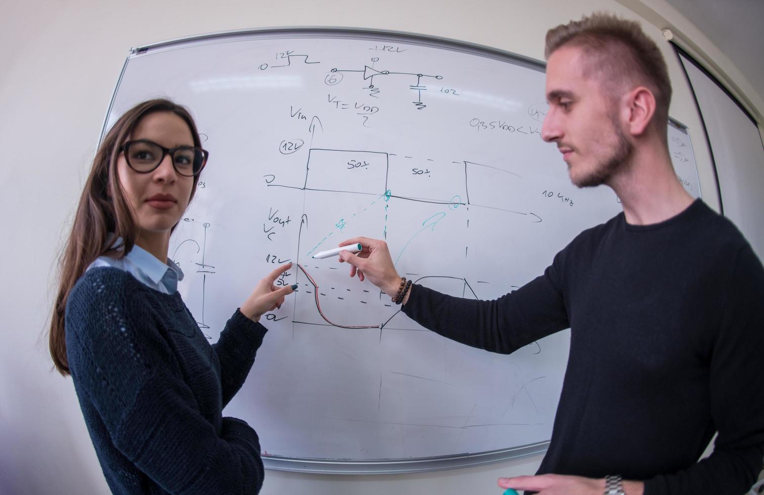 students writing on the white chalkboard photo