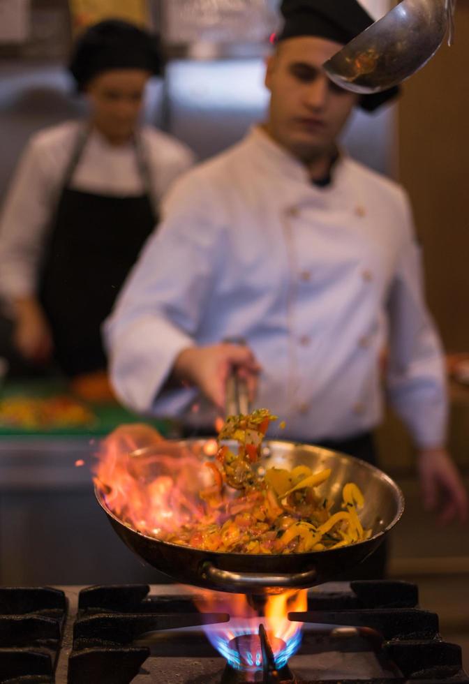 chef haciendo flambeado en la comida foto