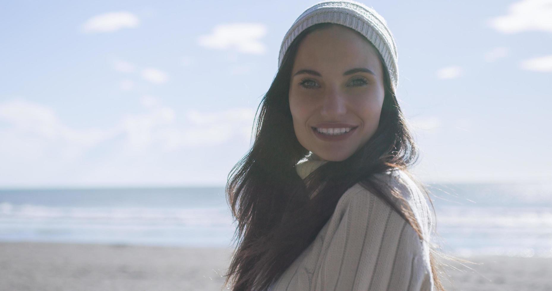 Girl In Autumn Clothes Smiling on beach photo
