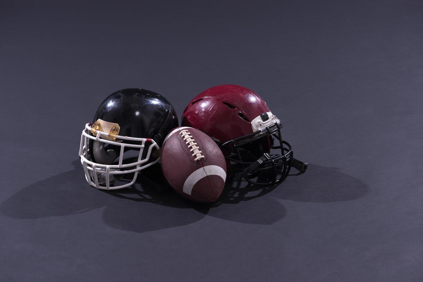 american football and helmets isolated on gray photo