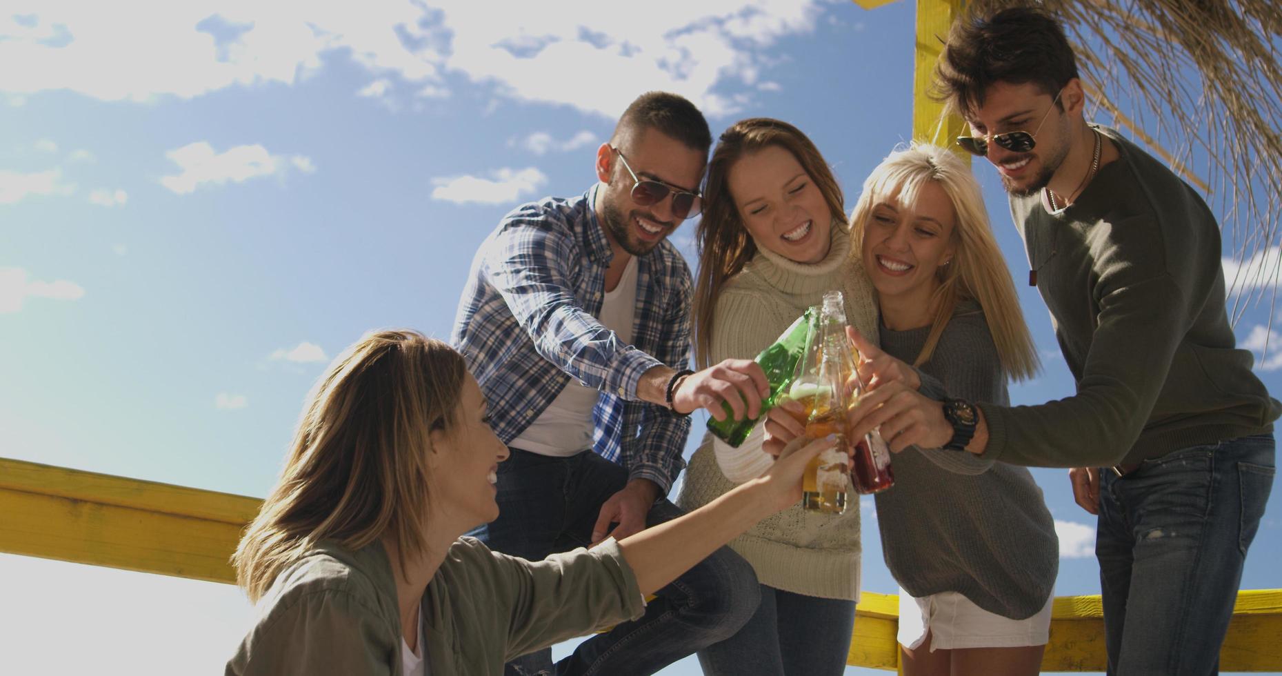 Group of friends having fun on autumn day at beach photo