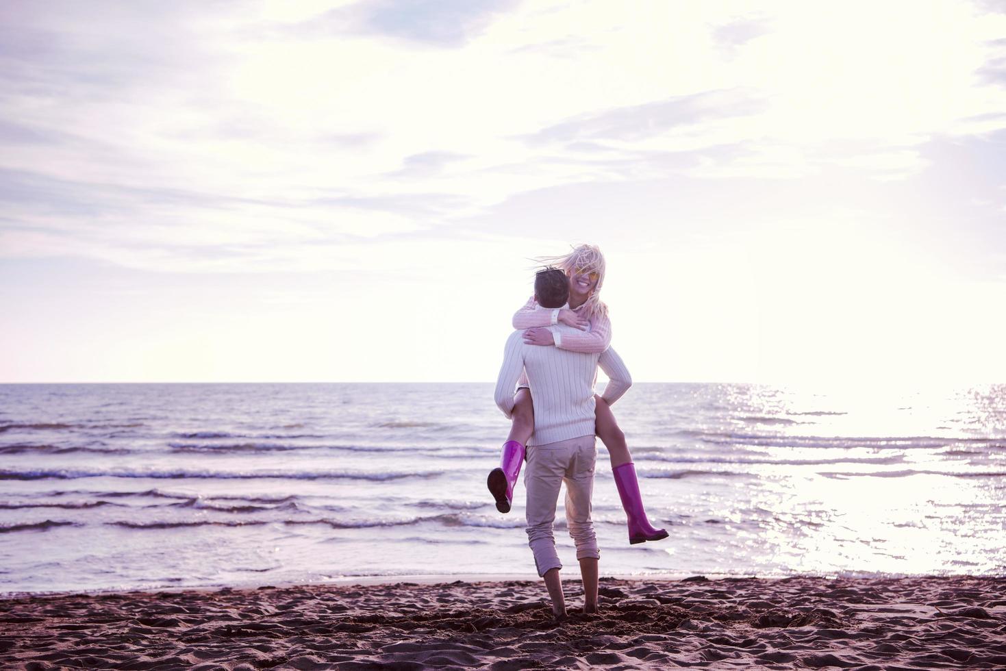 Loving young couple on a beach at autumn sunny day photo