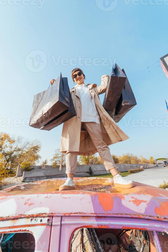 A young woman is standing in a car with bags in her hands photo