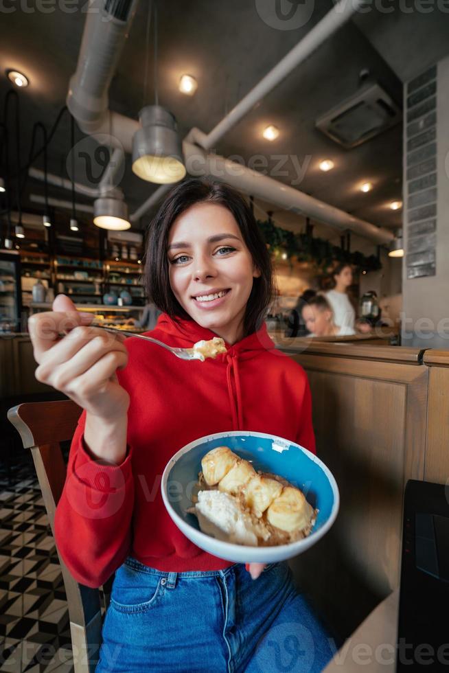 Young woman eating ice cream on a coffee shop photo