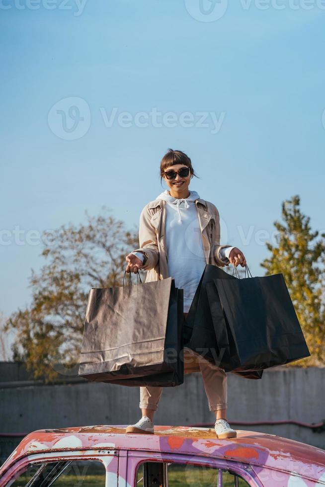 A young woman is standing in a car with bags in her hands photo