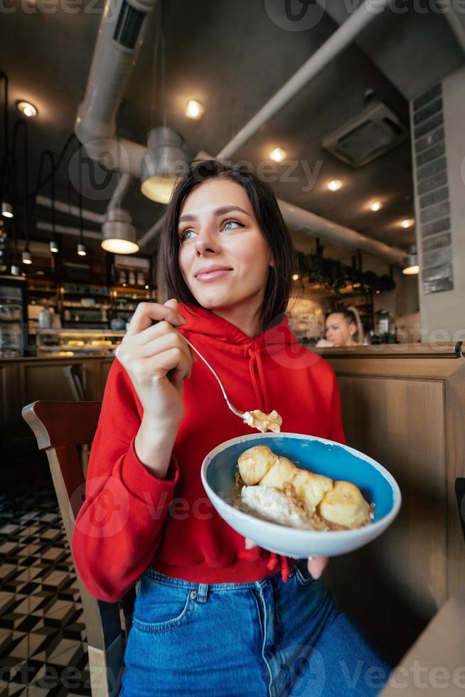 Young woman eating ice cream on a coffee shop photo