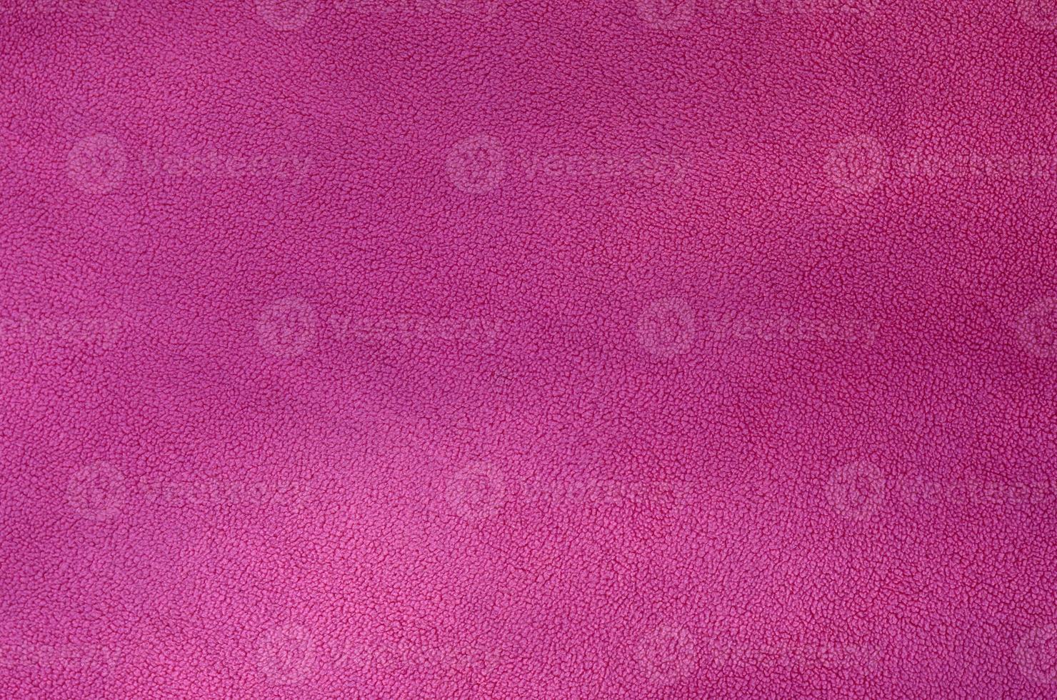 The blanket of furry pink fleece fabric. A background texture of light pink soft plush fleece material photo