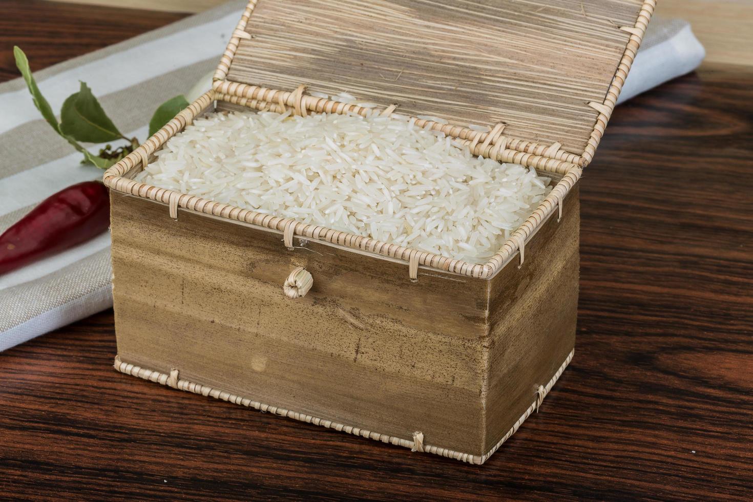 Basmati rice in a basket on wooden background photo