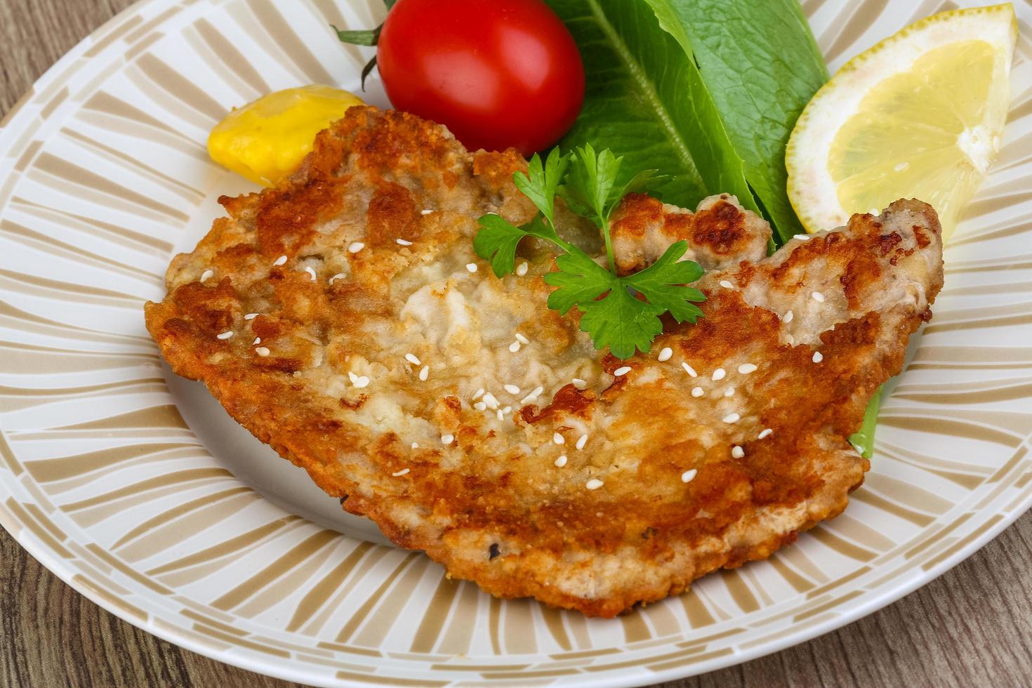Pork schnitzel on wood photo