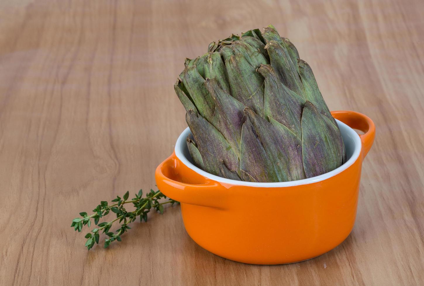 Raw artichokes on wood photo