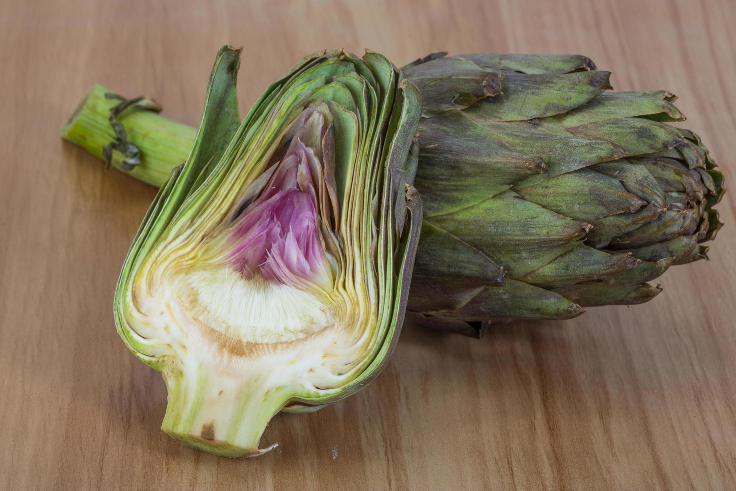 Raw artichokes on wood photo