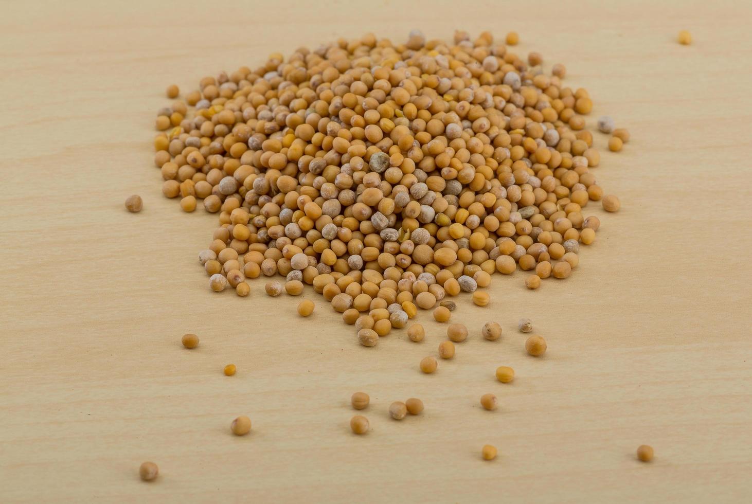 Mustard seeds on wooden background photo