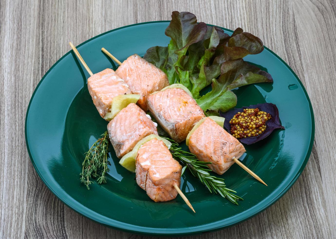 brocheta de salmón en madera foto