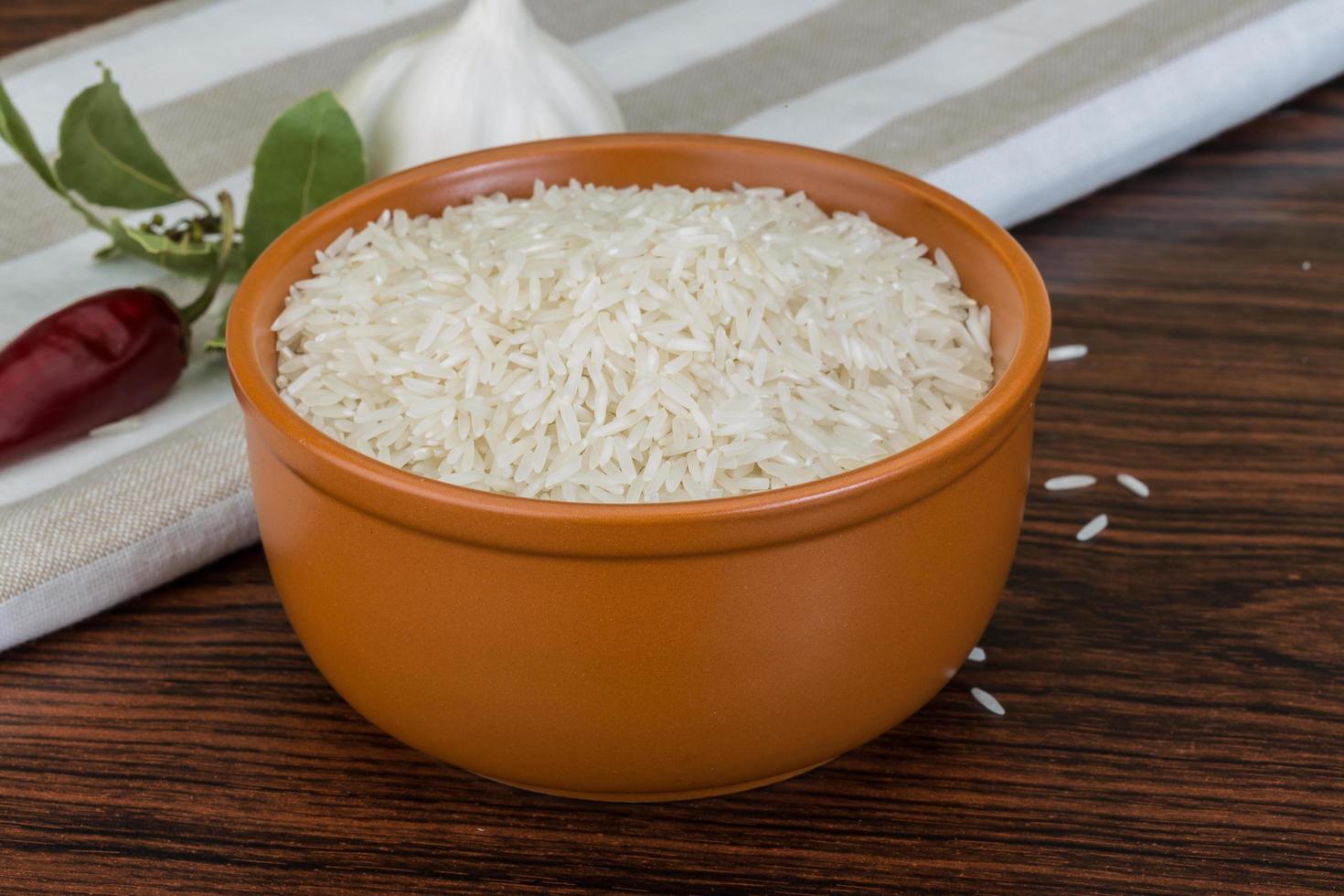 Basmati rice in a bowl on wooden background photo