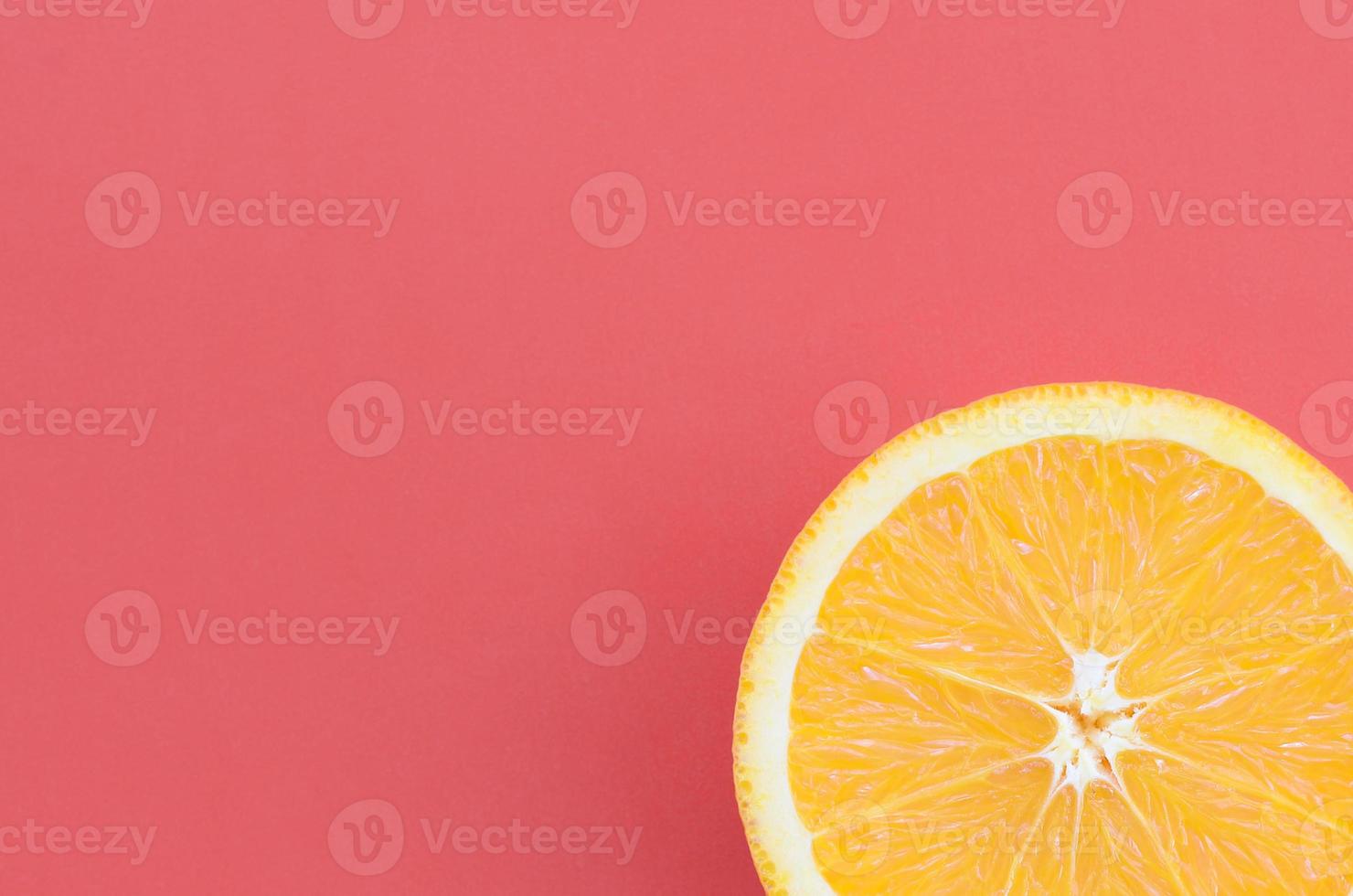 Top view of a one orange fruit slice on bright background in red color. A saturated citrus texture image photo