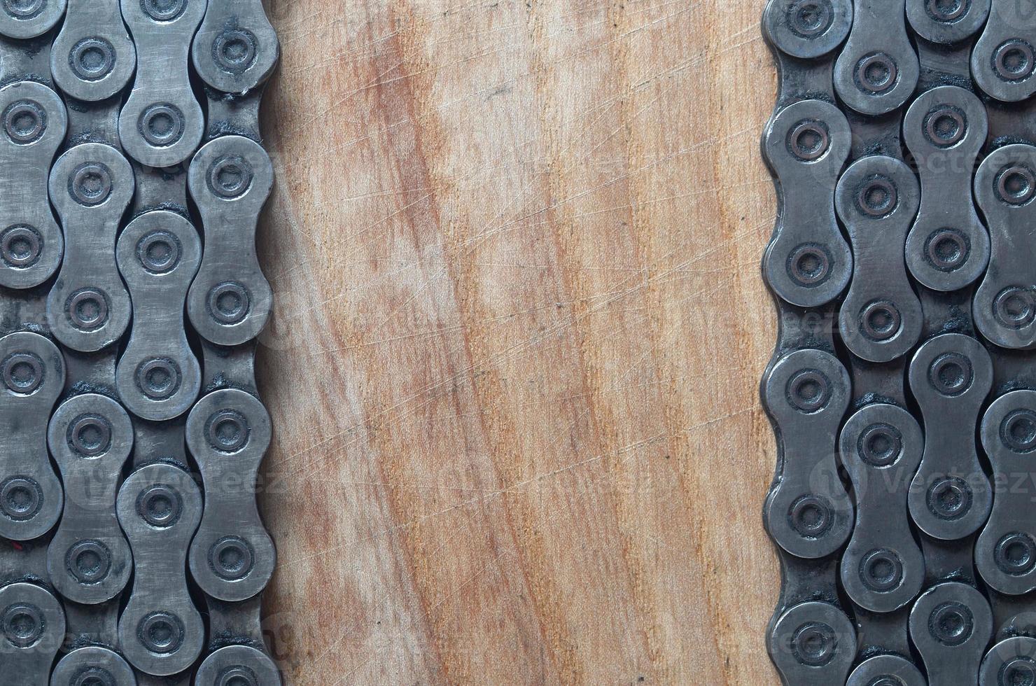 Dirty and oily chain from a mountain bike lying on a wooden table in a bicycle shop photo