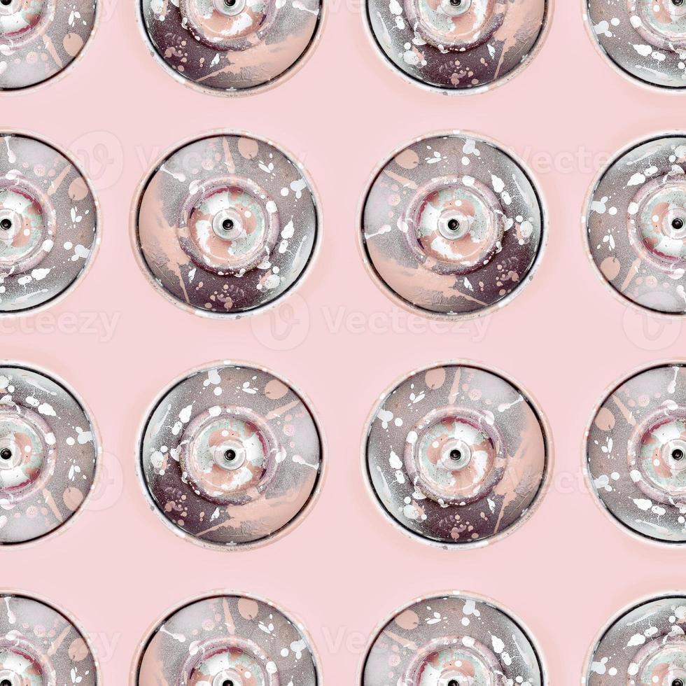 Many used spray cans for graffiti drawing lies on a pastel colored backgroung. Street art painting concept. Minimal flat lay pattern. Top view photo