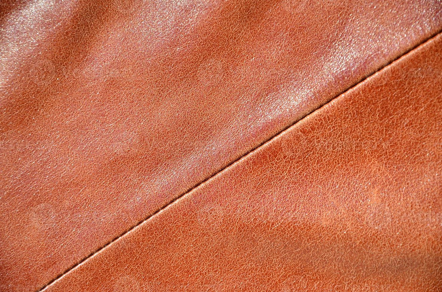 Brown leather texture. Useful as background for any design work. Macro photography of outerwear made of genuine leather photo